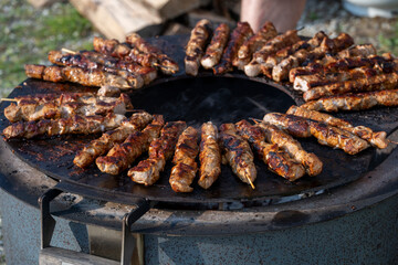 Cooking meat brochettes on a fire pit
