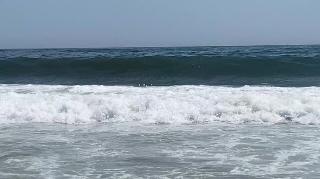 Close up of many large waves crashing onto the shore of the beaches of Long Island.