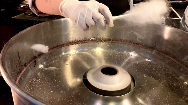 The making of cotton candy, sugar melt on a spinning machine, street food delicacy