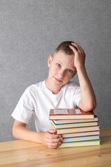 Pensive Young Boy Resting on a Stack of Books. World Dyslexia Awareness Day