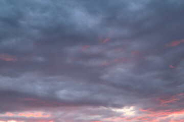 Dark, blue, orange cloud formations abstract nature background. Sky at sunset, orange cumulus clouds. Dramatic red and orange clouds.