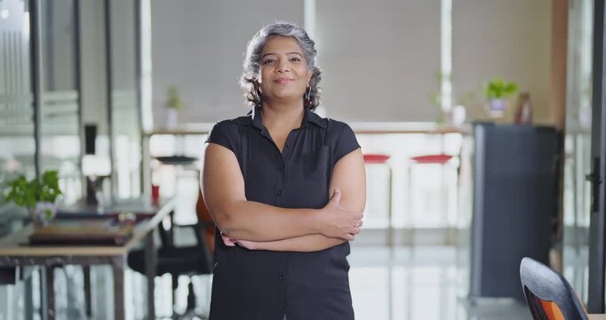 Indian Asian older aged adult boss ceo woman lady agent cross arms look cam do pose head shot video elder old gen x female worker staff expert standing proud fold hand indoor job office work place day
