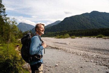 Senior man hiking in the mountains near a river in Germany.