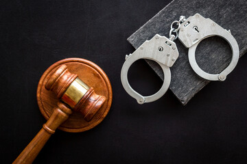 Police metal handcuffs with criminal code book and judges gavel. Law and justice concept