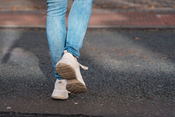 Woman Walking Along City Street in Casual Attire During Daylight Hours