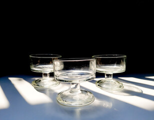 Aesthetic of transparent glasses for drink events with lines of sun shadow and glare on isolated background