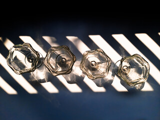 Aesthetic top view of transparent glasses for drink events with lines of sun shadow and glare on...