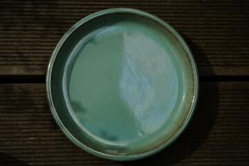 .minimalist turquoise plant coaster on wooden background