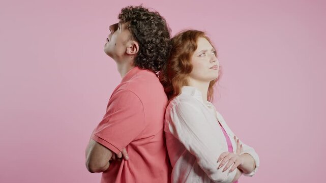 Young offended couple after quarreling, standing back. Selfishness, resentment