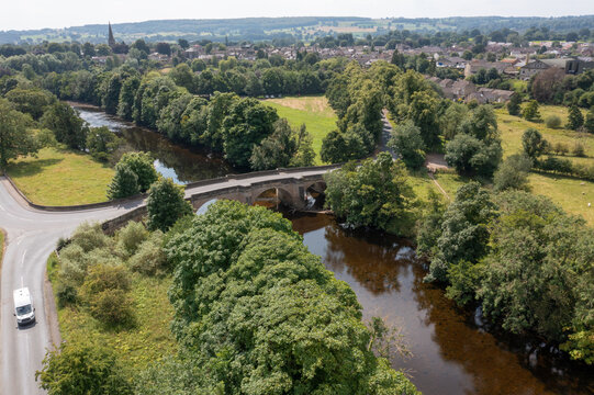Aerial photo of the beautiful town of Masham, Ripon in North Yorkshire in the UK showing the British countryside town from above and a bridge going in to the village in the summer time
