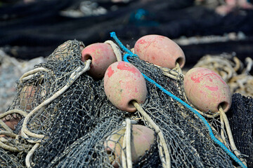 sieć rybacka z pływakami na brzegu, suszące sie na brzegu sieci rybackie z pływakami, fishing net on the shore, fishing net drying, Fishing net in the harbor, nets and floats are dried on the shore.
