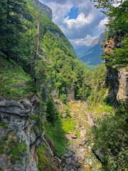 Scenic mountain valley in Monte Perdido and Ordesa in Pyrenees in Spain with wildflowers under cloudy sky.