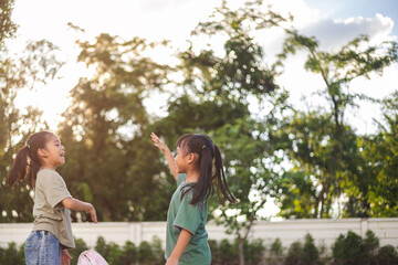 Fototapeta premium Two young girls are jumping with joy for taking action to keep the park clean.