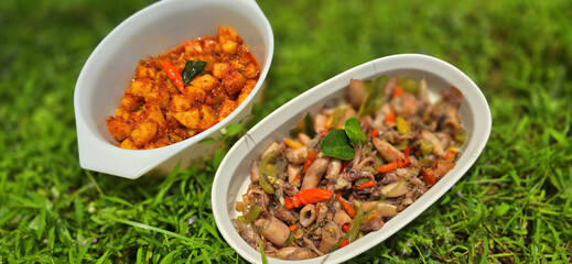 sauteed salty squid with black ink sauce with spicy seasoning called tumis cumi asin, is local Indonesian homemade cooking to include chili, ginger, and lime leaf served in a bowl