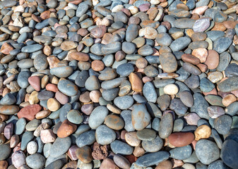 Background ofRounded Rocks on the Shore of the Ocean.