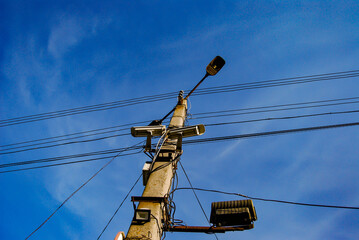 Concrete pole with electrical communications and street lights.
A concrete pillar against the sky,...