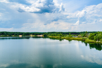 View on a lake in the abandoned sand quarry and dramatic sky