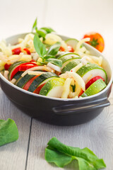 raw zucchini and tomatoes sliced and prepared for baking in a ceramic dish, vegetable appetizer