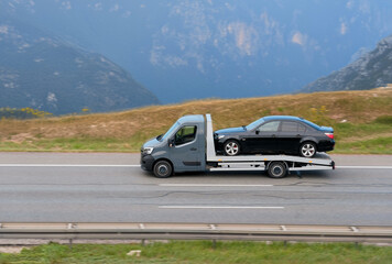 Fototapeta na wymiar Disabled Car Vehicle On Flatbed Towed By Truck