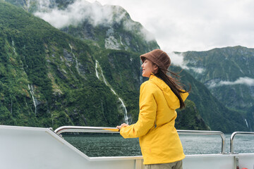Asian woman enjoying the view of Milford Sound during ferry cruise on vacation at New Zealand