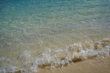 Waves on the edge of the sand on the beaches in the Bahamas. Natural background.