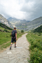 Hiker walking on a stone path in a mountainous landscape of Monte Perdido, Spain