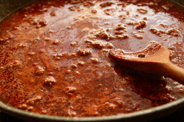 cooking, bolognese sauce, in a frying pan, stirring with a wooden spoon, tomato meat sauce, homemade, no people,