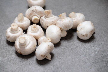 Raw mini mushroom champignon in a gray background. Top view