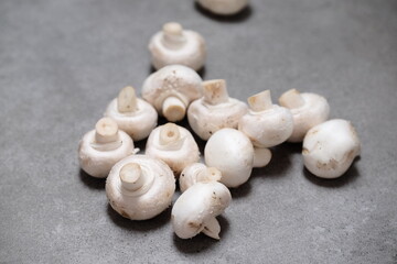 Raw mini mushroom champignon in a gray background. Top view