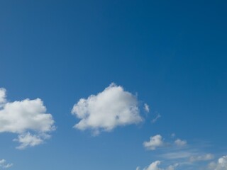 Summer white fluffy cumulus clouds in the deep blue sky