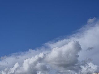 Summer white fluffy cumulus clouds in the deep blue sky