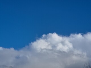 Summer white fluffy cumulus clouds in the deep blue sky