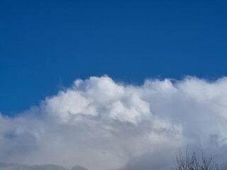 Summer white fluffy cumulus clouds in the deep blue sky