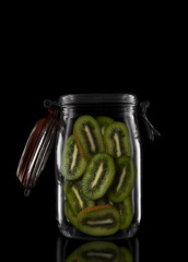 A glass storage or canning jar isolated on black with reflection, with lid open.