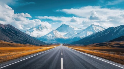 Fototapeta premium Empty highway leading to snow-capped mountains with a backdrop of cloudy skies, showcasing natural beauty.