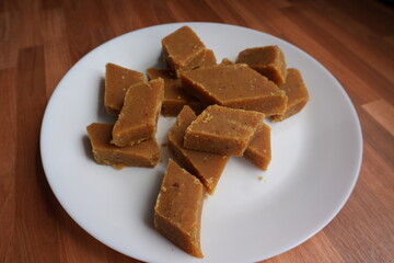 
A rich, golden-brown Chana Dal Halwa, cut into diamond-shaped pieces, glistens with ghee, promising a sumptuous and melt-in-the-mouth experience