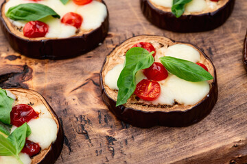 Italian mini pizza . Aubergine (eggplant ) with mozzarella cheese and basil . On rustic background