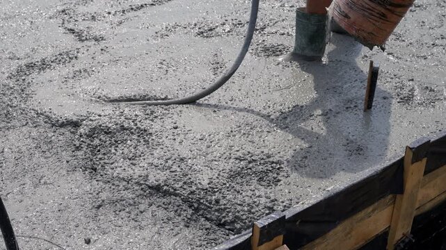 Vibration work with liquid concrete at the construction site. Concrete compaction process. Close-up.