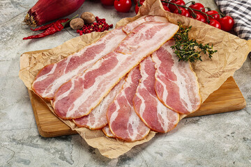 Sliced pork bacon over board