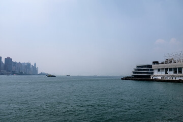 Obraz premium The view from Tsim Sha Tsui Victoria Harbour, Hong Kong. Iconic terminal and Hong Kong cityscape. Travel and nature scene. 