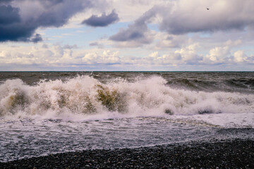 Black Sea at sunset. Waves on the sea, sea foam and sand.