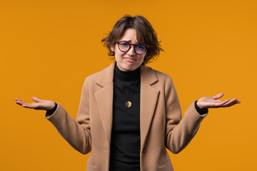 Confused businesswoman, shoulders up - can't help, makes gesture of I dont know