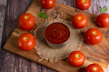 Fresh Red Tomatoes and Tomato Sauce on Rustic Wooden Board