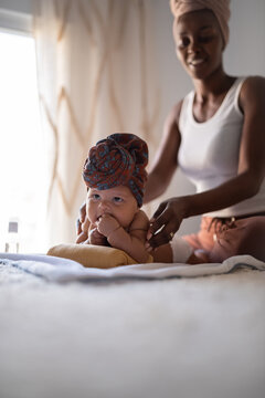 Smiling mother massaging newborn