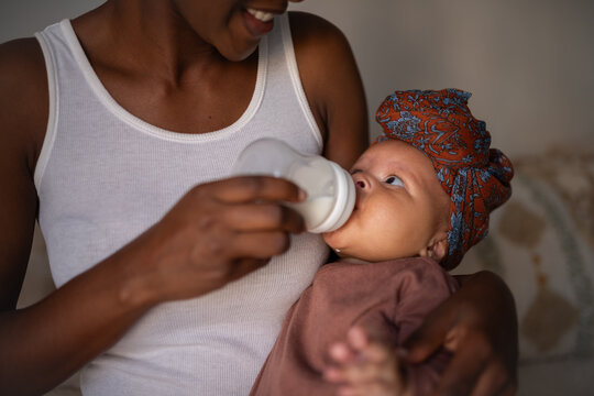 Smiling woman feeding newborn