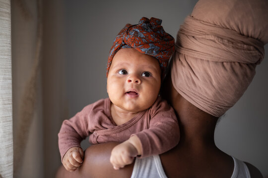 Black woman carrying baby at home