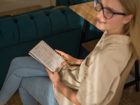 Happy woman holding notebook with numbers