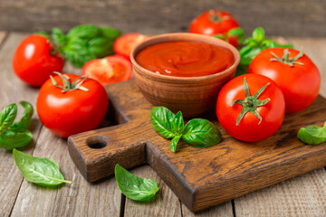 Fresh cherry tomatoes and fresh green basil on a textured background. Tomato sauce. Vegan. Ingredients for salad. Organic food. Place for text. Copy space.