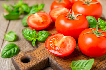 Fresh cherry tomatoes and fresh green basil on a textured background. Tomato sauce. Vegan. Ingredients for salad. Organic food. Place for text. Copy space.