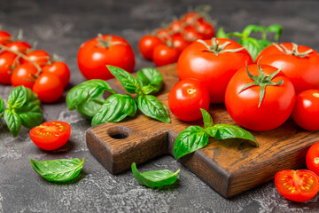 Fresh cherry tomatoes and fresh green basil on a textured background. Tomato sauce. Vegan. Ingredients for salad. Organic food. Place for text. Copy space.